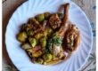 “Plato hondo con guiso mediterráneo de conejo y coles de Bruselas, acompañado de sofrito de tomate, ajo y cebolla, sobre fondo rústico de madera. Receta saludable de temporada.”